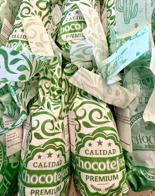 Coconut chocotejas in green paper wrappers.