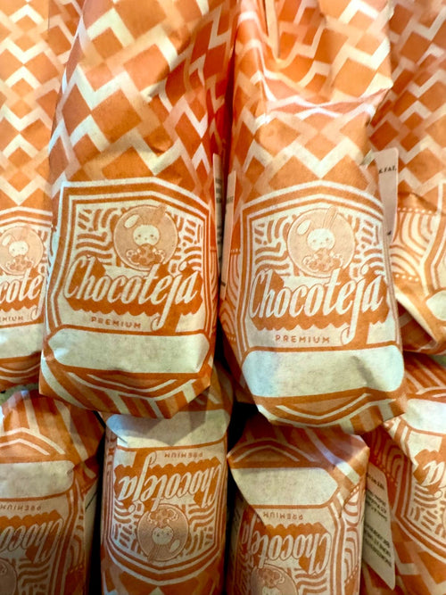 Pecan chocotejas in orange paper wrappers.